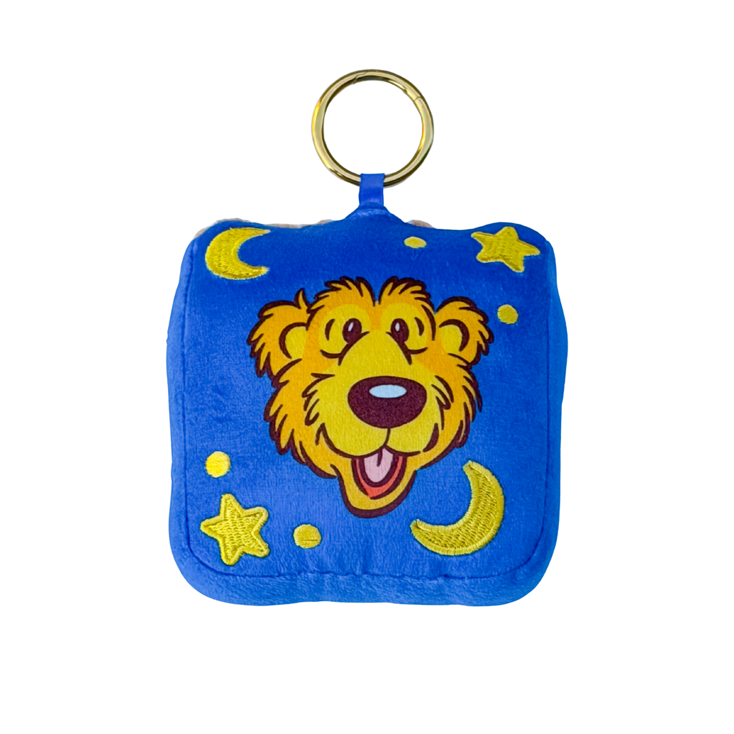 A square blue plush pouch or keychain bag with a gold metal ring at the top. The front features a cartoon bear face in yellow, brown, and pink, surrounded by yellow stars and crescent moons on a blue background.